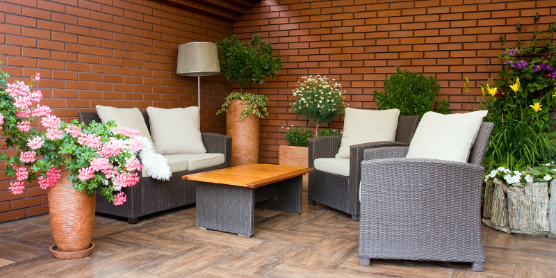 Image of gray and white outdoor furniture against brick wall.