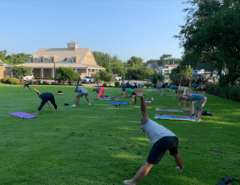 Crowd of people doing yoga on the Duck Town Green.
