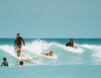 Image of small waves with 8 people in various stages of surfing.