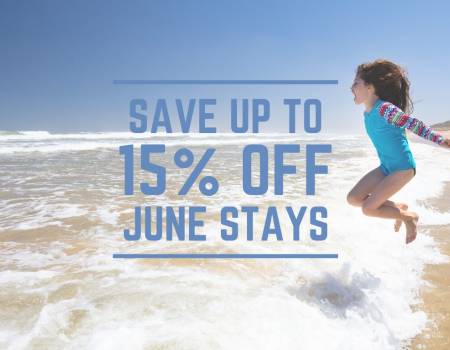Young girl jumping into the shoreline on a sunny beach.