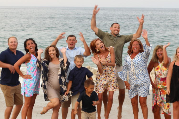 Portrait of multi-generational family jumping on the beach.