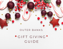 Outer Banks Gift Giving Guide text against cream colored background with red ornaments.