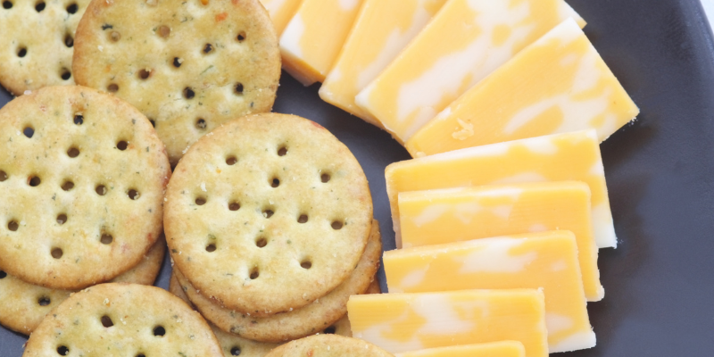 Plate with round crackers and white and yellow Colby cheese.