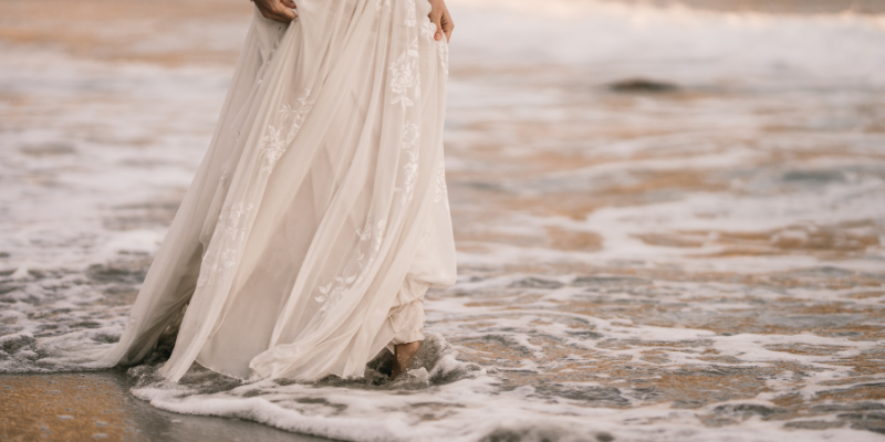 Woman walking in ocean in wedding dress