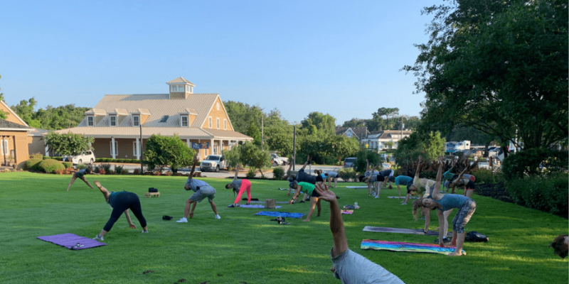 Crowd of people doing yoga on the Duck Town Green.