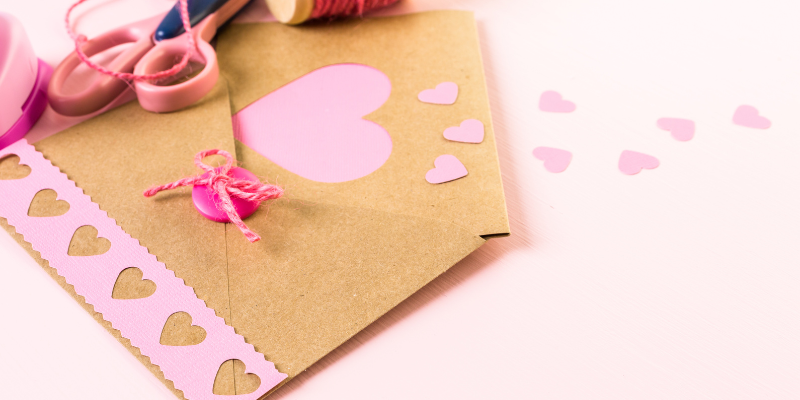 Pink and tan envelope with red hearts along the edge.