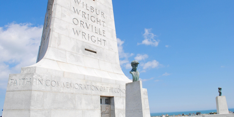 Wright Brothers Memorial - Gray monument against blue sky.