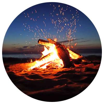 Beach campfire with bright orange flames and sparks 