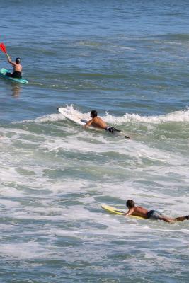 Image of people surfing and kayaking in the ocean.